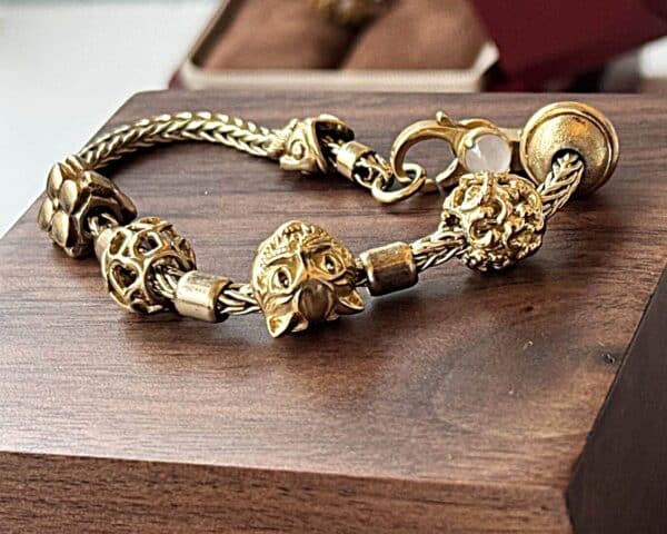 14 karat guld armbånd, med 18 karat guld charms (Trollbeads)
